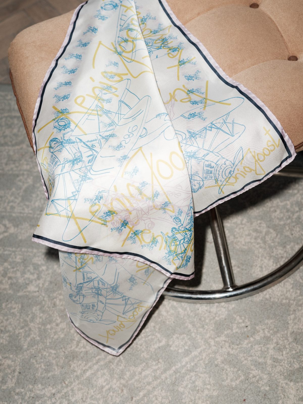 ABOVE THE SKY silk scarf by Xenia Joost draped over a metal chair