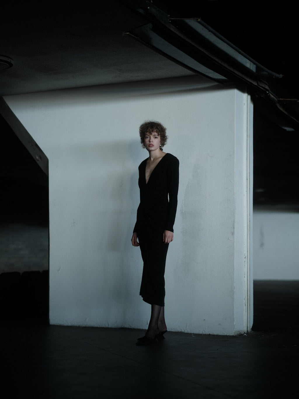 RENDEVOUZ DRESS by Xenia Joost, front view of black shimmering midi dress with deep V-neck