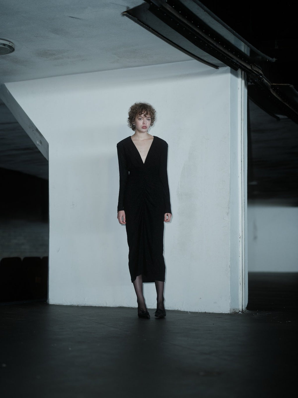 RENDEVOUZ DRESS by Xenia Joost, detail of deep V-neck, structured shoulders and shimmering black fabric