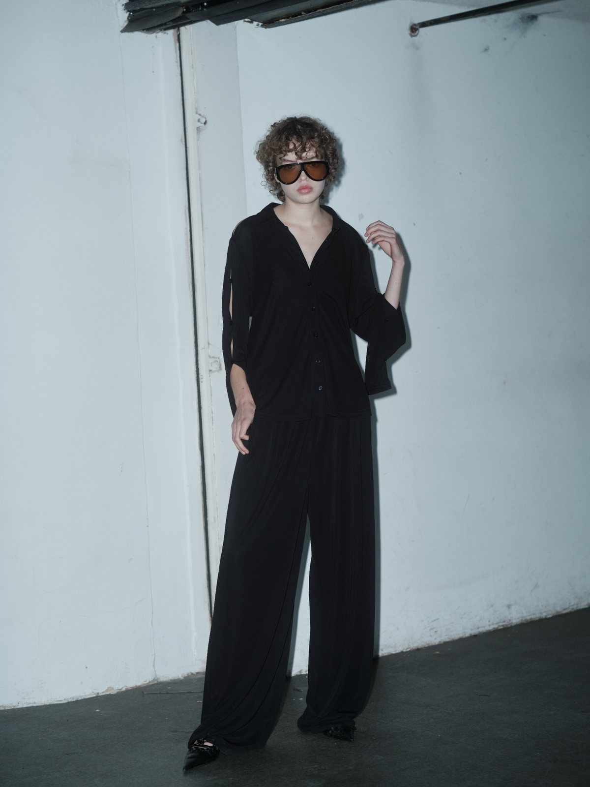 SLEEK VENTURA top in black by Xenia Joost, side view showing the buttoned open sleeve