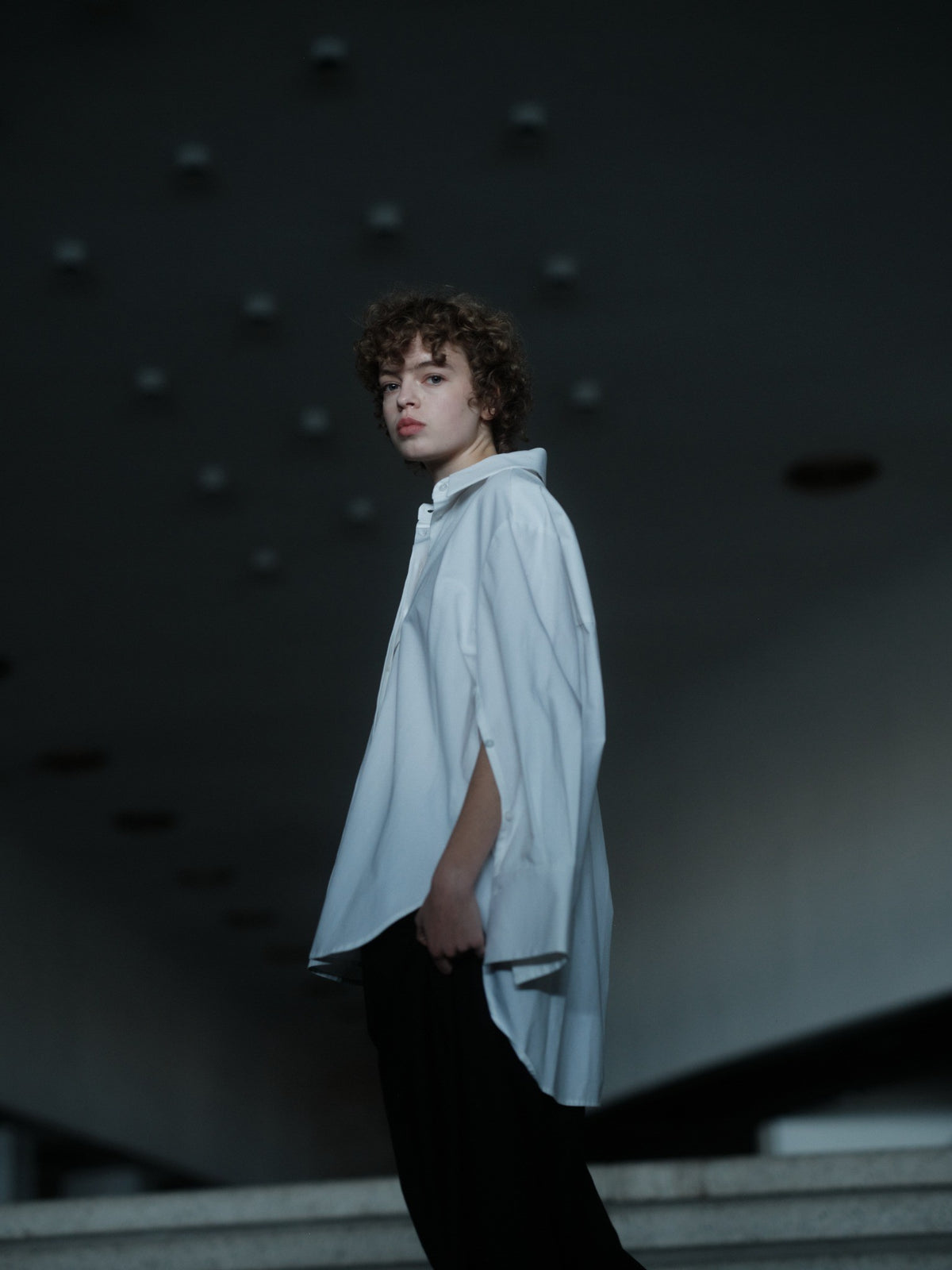 Xenia Joost The Statement Shirt — Button Down 001 in white, side view with an open sleeve showing its adjustable construction.